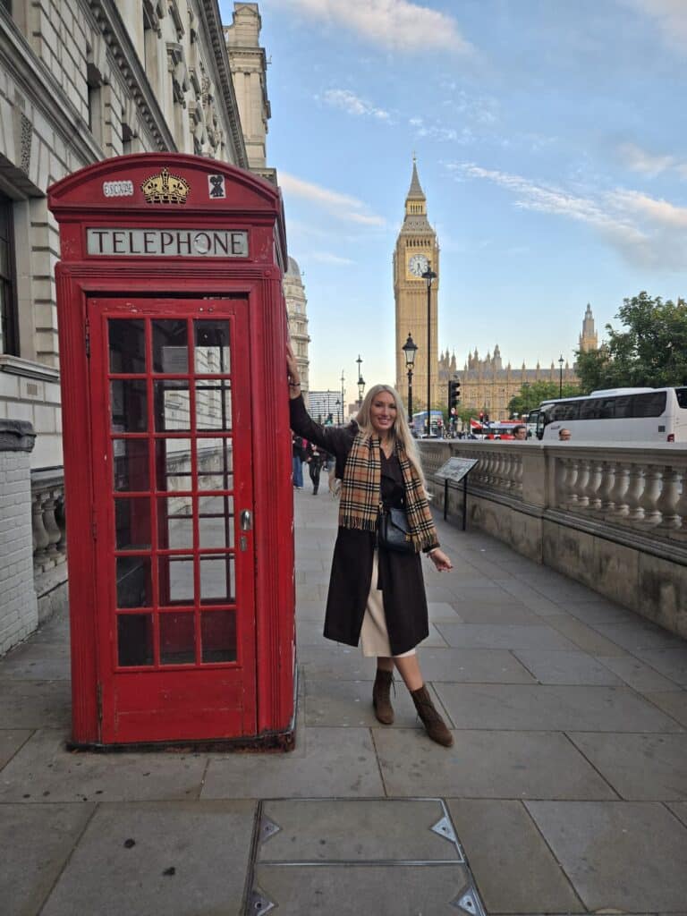 Day tours from London England: Tourist posing by red telephone booth with Big Ben and Houses of Parliament in background