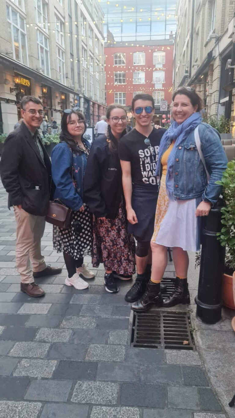 Happy group enjoying 2 day tours from London with London Sightseeing Taxi Tours in a vibrant London street