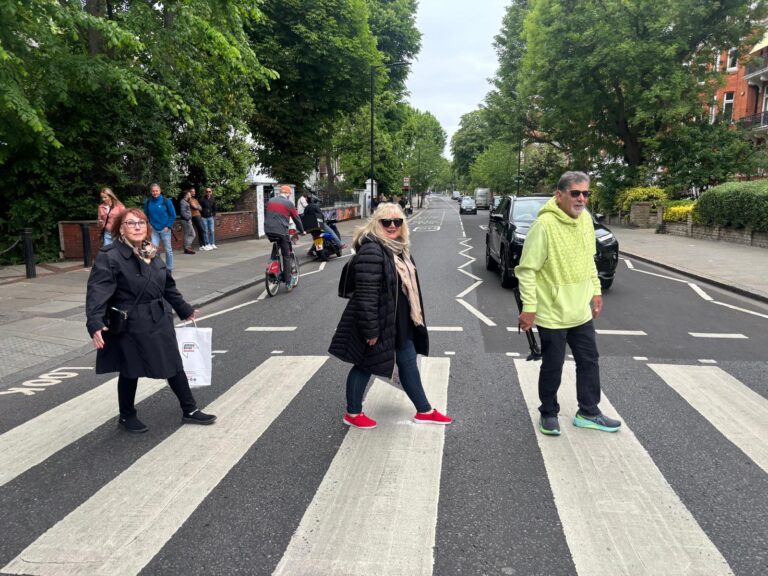 People crossing a picturesque London street during day tours out of London with London Sightseeing Taxi Tours, capturing the charm of the city for groups up to six