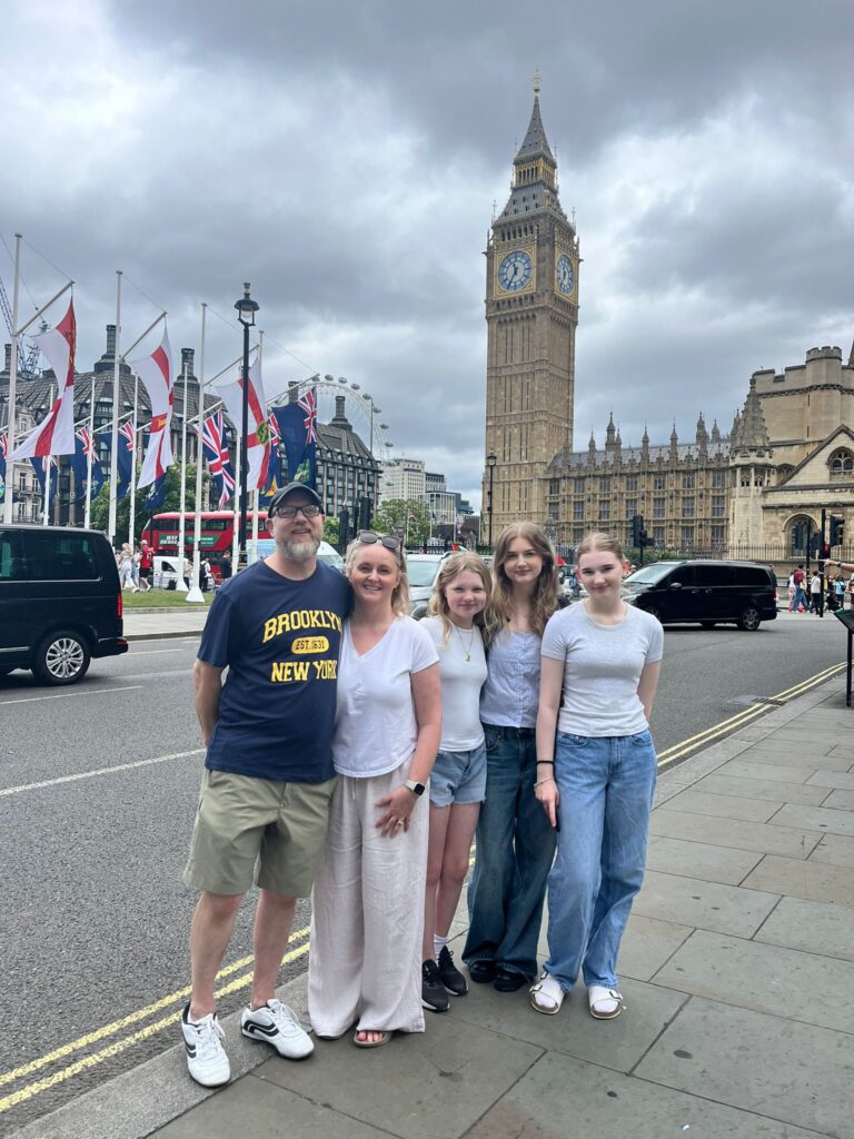 Happy family visiting Big Ben in London as part of cheap Stonehenge tours from London with wheelchair-accessible sightseeing taxi tours