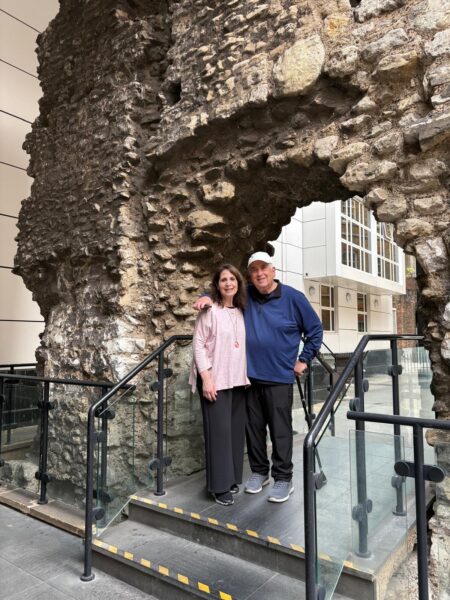 Best England tour companies: Visitors enjoying London sightseeing taxi tours at ancient stone archway with wheelchair-accessible vehicles for up to six people