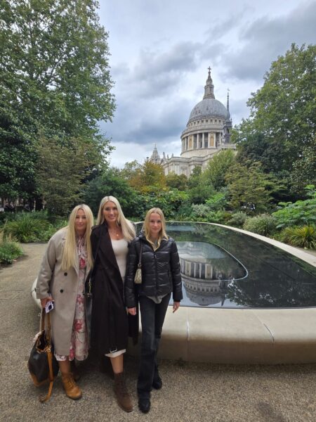 Tourists enjoying a guided tour of London with local insights from a black cab driver