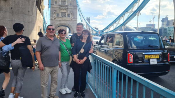 Tourists visiting famous London landmarks with Londra Get Your Guide service in a traditional black cab