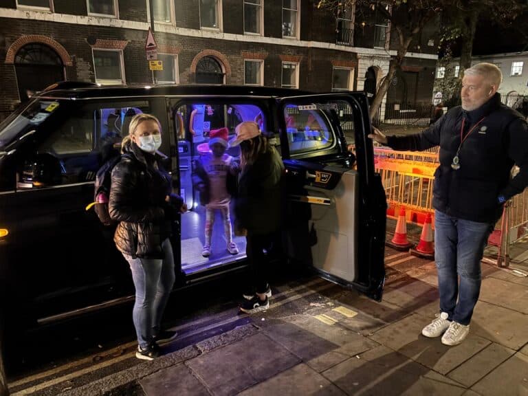 Black taxi in London with street art murals for sightseeing tour