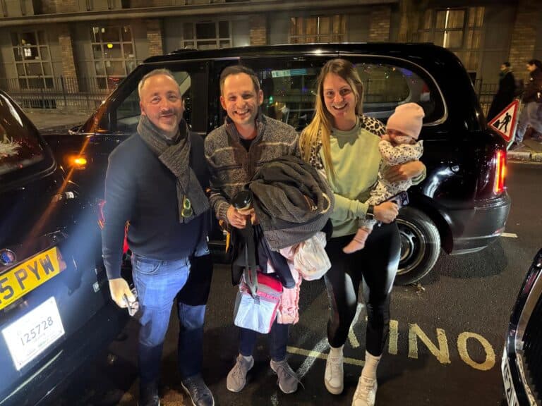 Tourists on a London escorted tour package in a black taxi cab